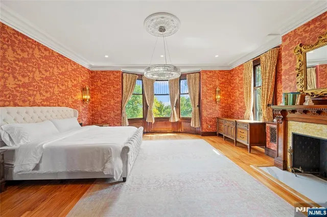 a spacious bedroom with a large bed and a chandelier