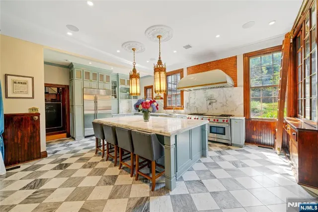 a kitchen with stainless steel appliances kitchen island granite countertop a table chairs and a refrigerator