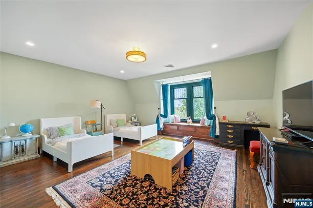 a bedroom with furniture and a large window