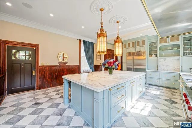 a hall view with a sink dishwasher a dining table and chairs with wooden floor