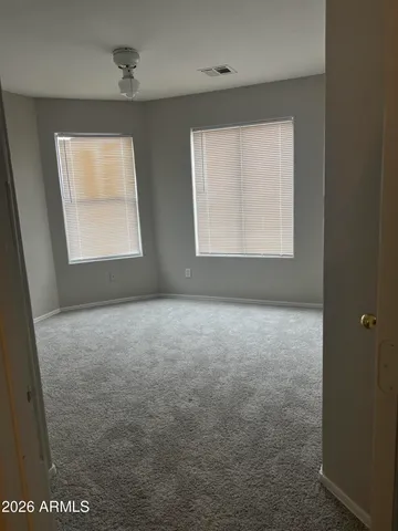 a view of an empty room with a chandelier fan