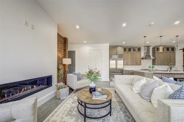 a living room with furniture and a dining table with kitchen view