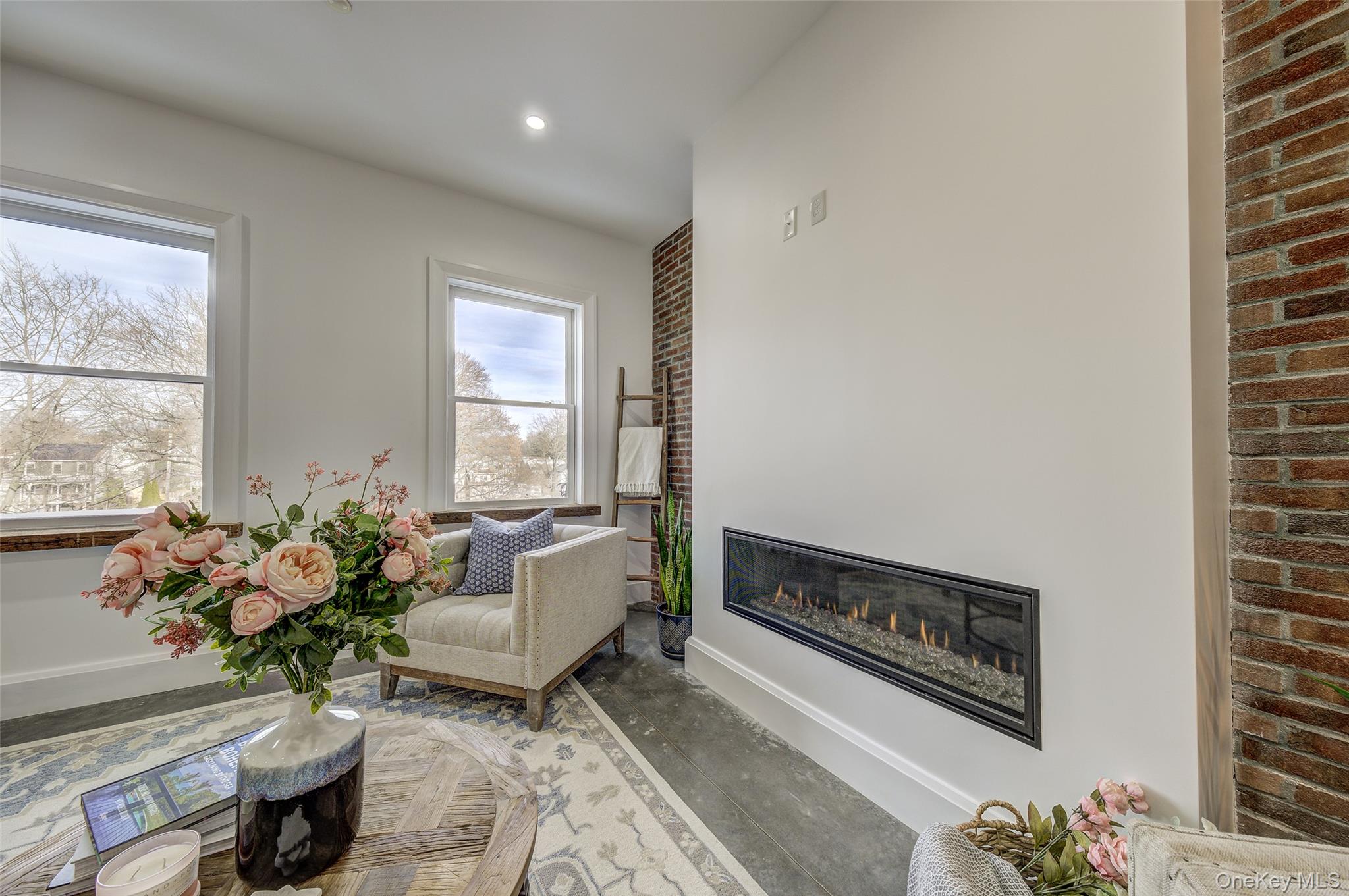 226 Main Street, Unit 302 Beacon, NY 12508 - Photo 20 of 43 Sitting room featuring a glass covered fireplace, brick wall, and recessed lighting