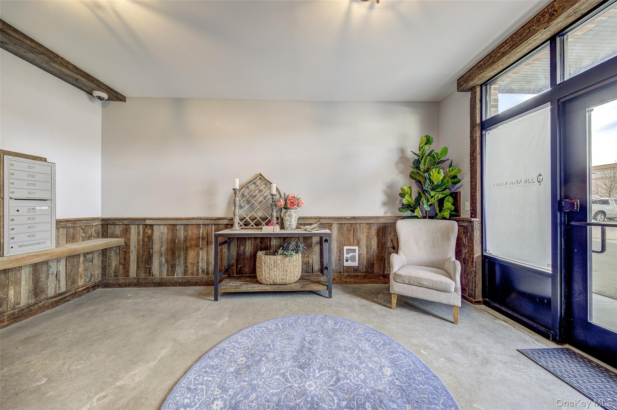 226 Main Street, Unit 302 Beacon, NY 12508 - Photo 2 of 43 Living area with concrete flooring, wooden walls, a wainscoted wall, and beamed ceiling