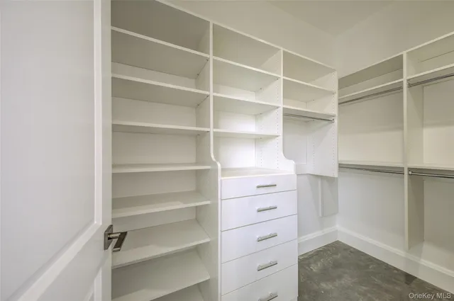 a view of walk in closet with empty racks