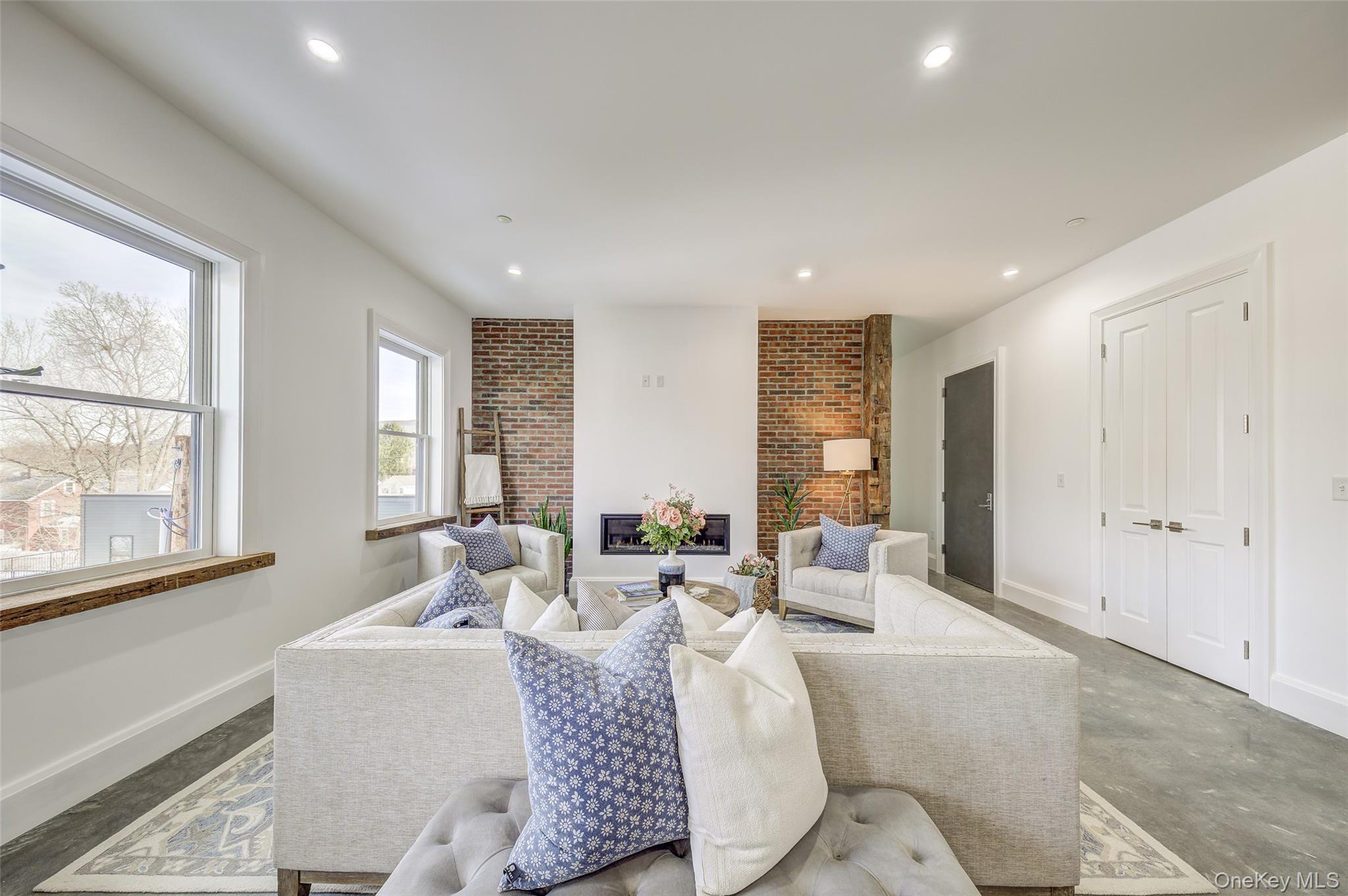 226 Main Street, Unit 302 Beacon, NY 12508 - Photo 10 of 43 Living room featuring recessed lighting, a glass covered fireplace, and concrete flooring