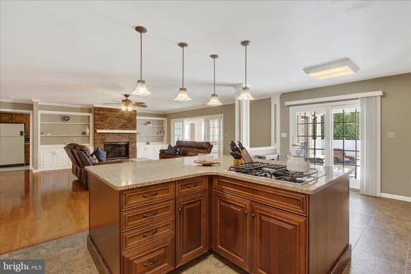 a kitchen with stainless steel appliances granite countertop a sink a stove and a wooden floor