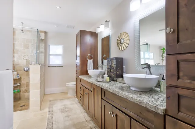a spacious bathroom with a granite countertop sink and a large mirror