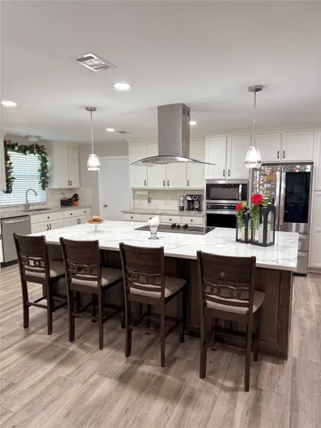 a kitchen with a dining table chairs and white cabinets