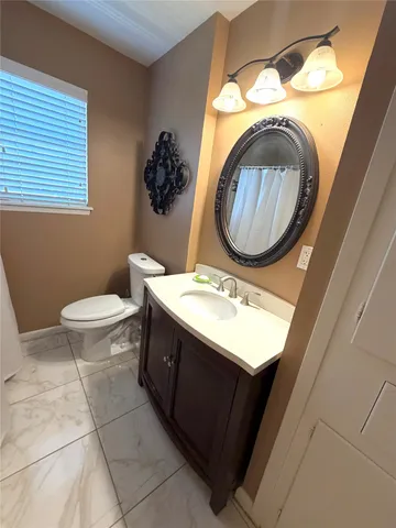 a bathroom with a toilet a sink and a mirror