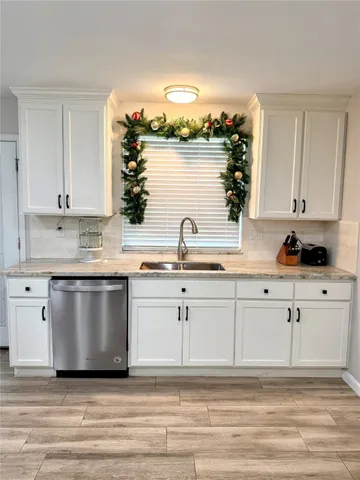 a white kitchen with sink and cabinets