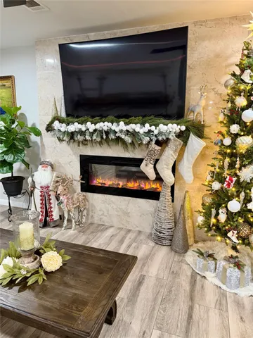 a living room with fireplace furniture and a potted plant