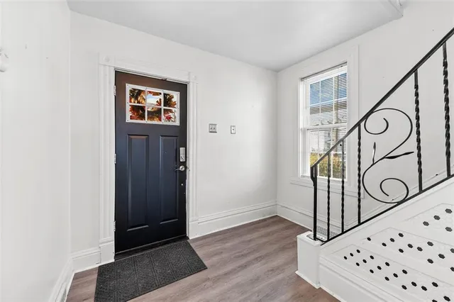 a view of a hallway with wooden floor and entryway