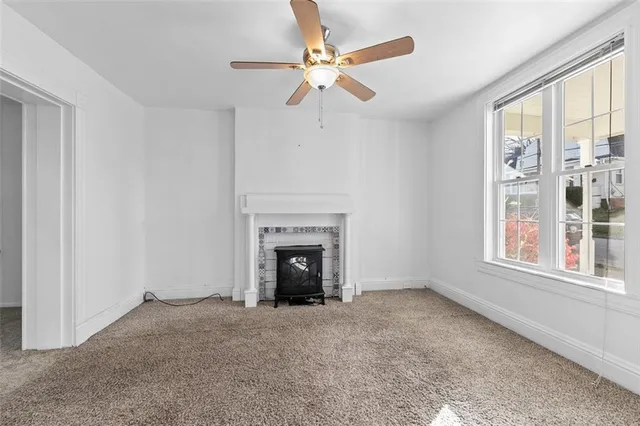 wooden floor fireplace and windows in an empty room