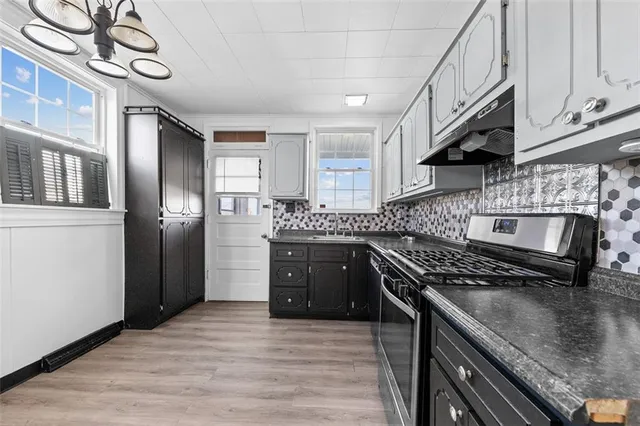 a kitchen with stainless steel appliances granite countertop a stove a sink and a refrigerator