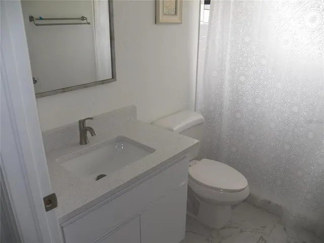 a white toilet sitting next to a white sink