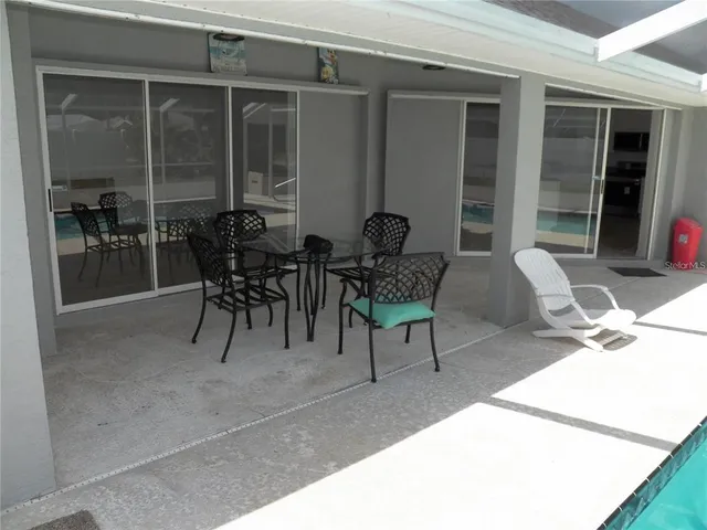 a view of a patio with table and chairs and potted plants