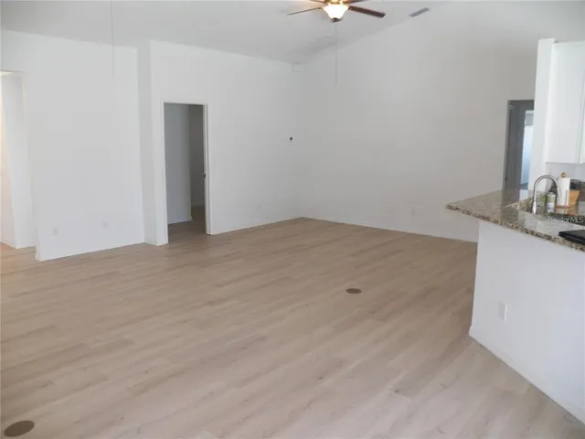a view of a kitchen with wooden floor and a sink