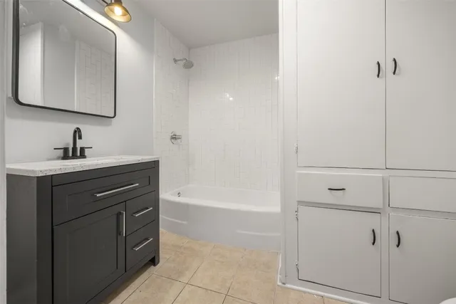 a bathroom with a bathtub sink vanity and mirror