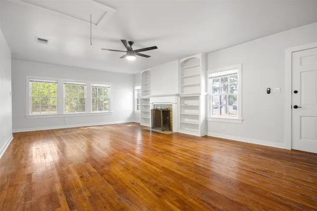 a view of empty room with wooden floor and fireplace