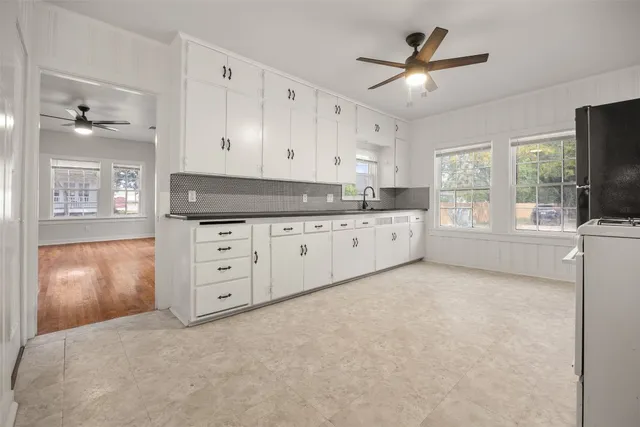 a kitchen with granite countertop a stove a sink and a refrigerator with wooden floor