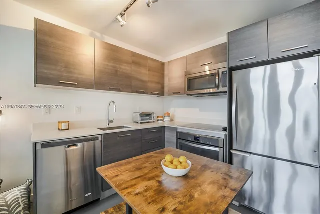 a kitchen with stainless steel appliances granite countertop a sink refrigerator and microwave