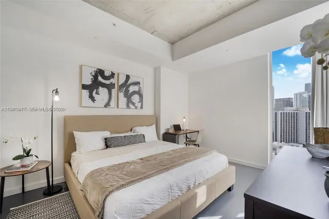 a bedroom with a bed and painting on the wall