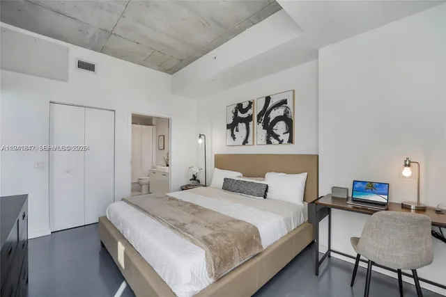 a bedroom with a bed and a desk