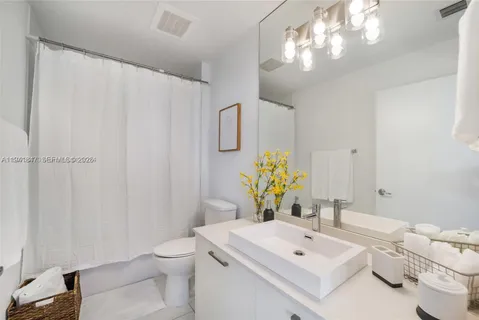 a bathroom with a sink a toilet and a mirror