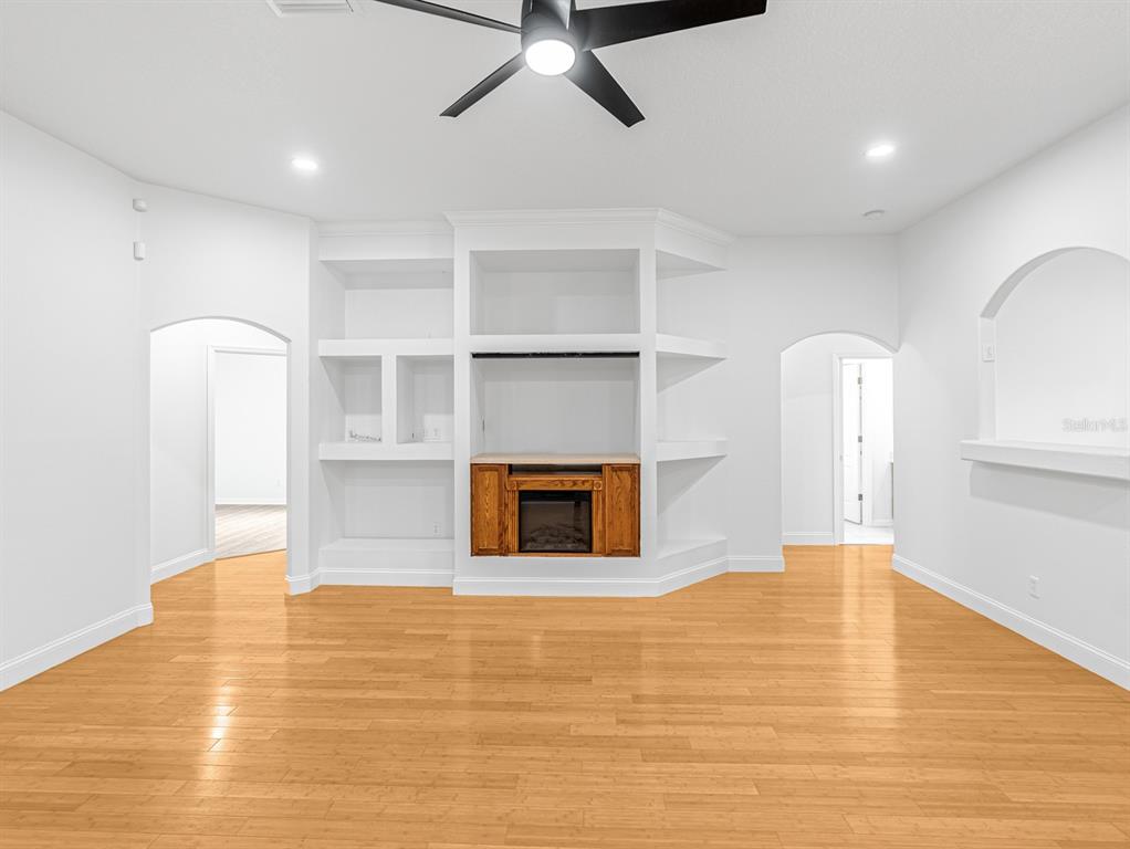 1670 Taylor Ridge Loop Kissimmee, FL 34744 - Photo 12 of 36 a view of empty room with wooden floor and fireplace