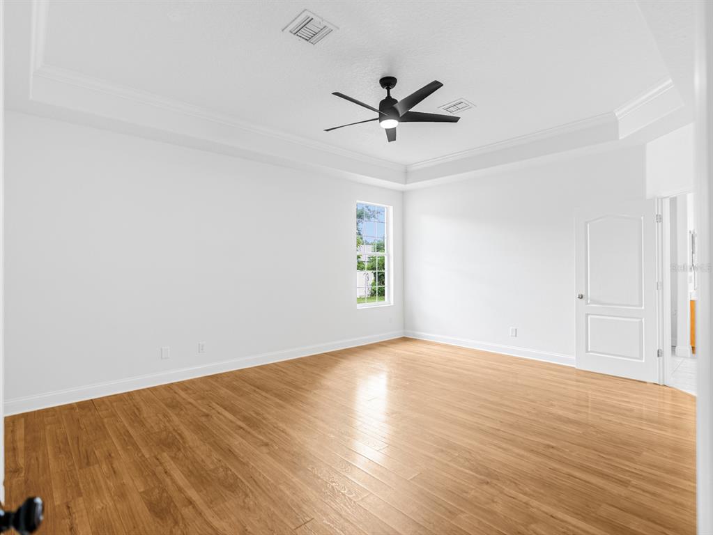 1670 Taylor Ridge Loop Kissimmee, FL 34744 - Photo 17 of 36 a view of an empty room with wooden floor and a window