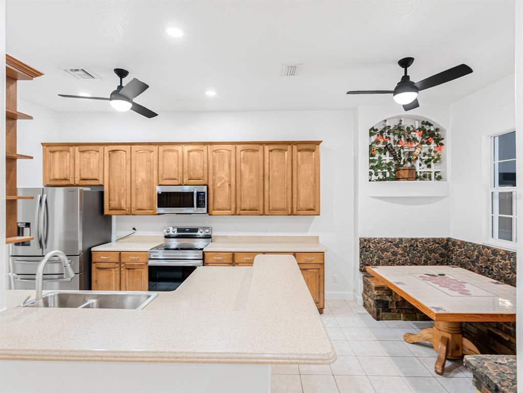 1670 Taylor Ridge Loop Kissimmee, FL 34744 - Photo 19 of 36 a living room with stainless steel appliances kitchen island granite countertop a sink a stove and a refrigerator