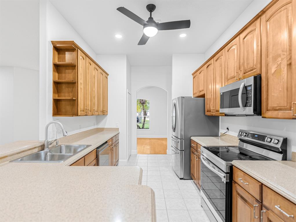 1670 Taylor Ridge Loop Kissimmee, FL 34744 - Photo 21 of 36 a kitchen with stainless steel appliances granite countertop a sink stove and refrigerator
