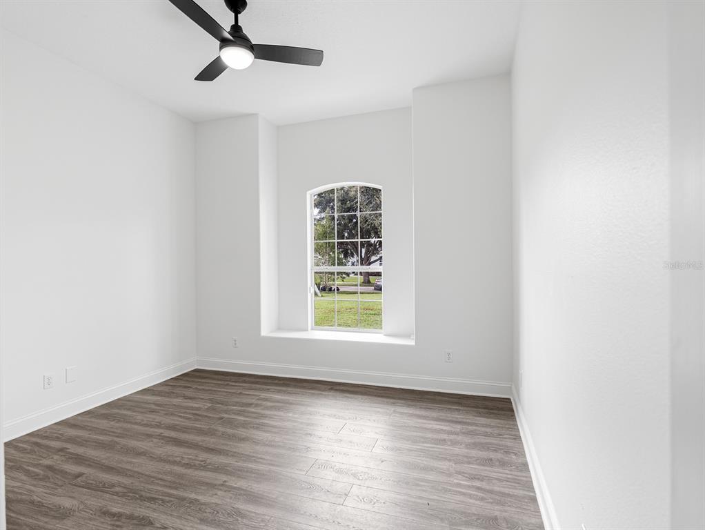 1670 Taylor Ridge Loop Kissimmee, FL 34744 - Photo 22 of 36 an empty room with wooden floor cabinet and windows
