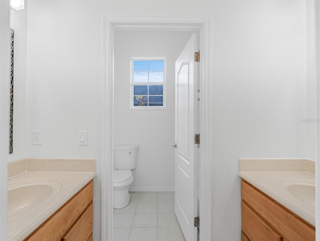 1670 Taylor Ridge Loop Kissimmee, FL 34744 - Photo 23 of 36 a bathroom with a granite countertop sink a toilet and shower