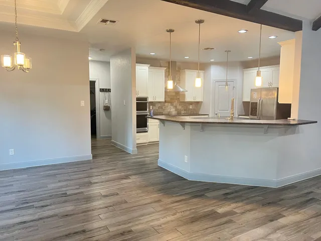 a large kitchen with stainless steel appliances granite countertop a large stove a sink and a refrigerator