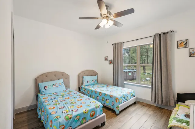 a bedroom with two beds and wooden floor