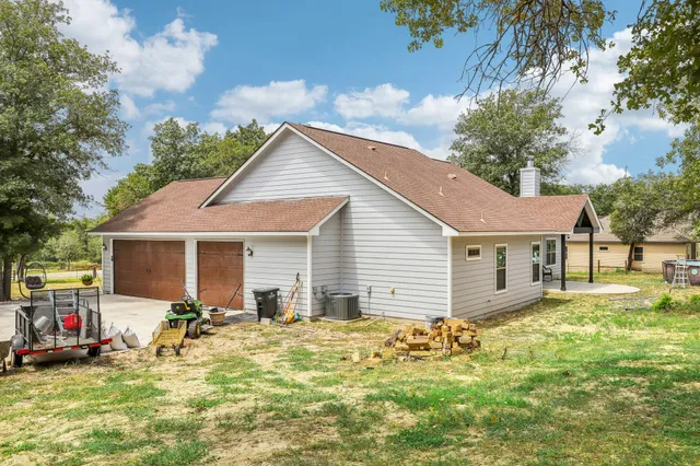 a view of a house with a yard and potted plants