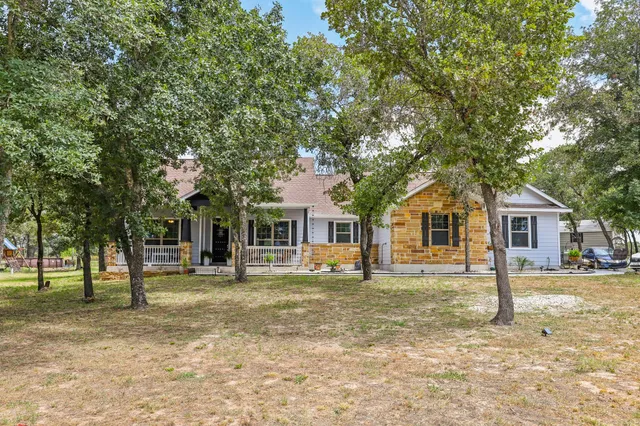 an empty room with wooden floor fireplace and windows
