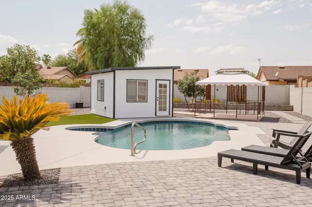 a swimming pool with outdoor seating and yard