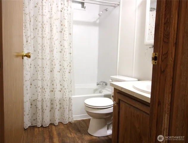 a bathroom with a granite countertop toilet and a sink