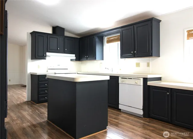 a kitchen with kitchen island granite countertop wooden cabinets and sink