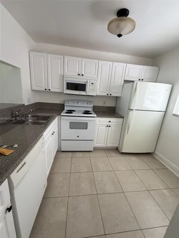 a kitchen with a stove a sink and a refrigerator