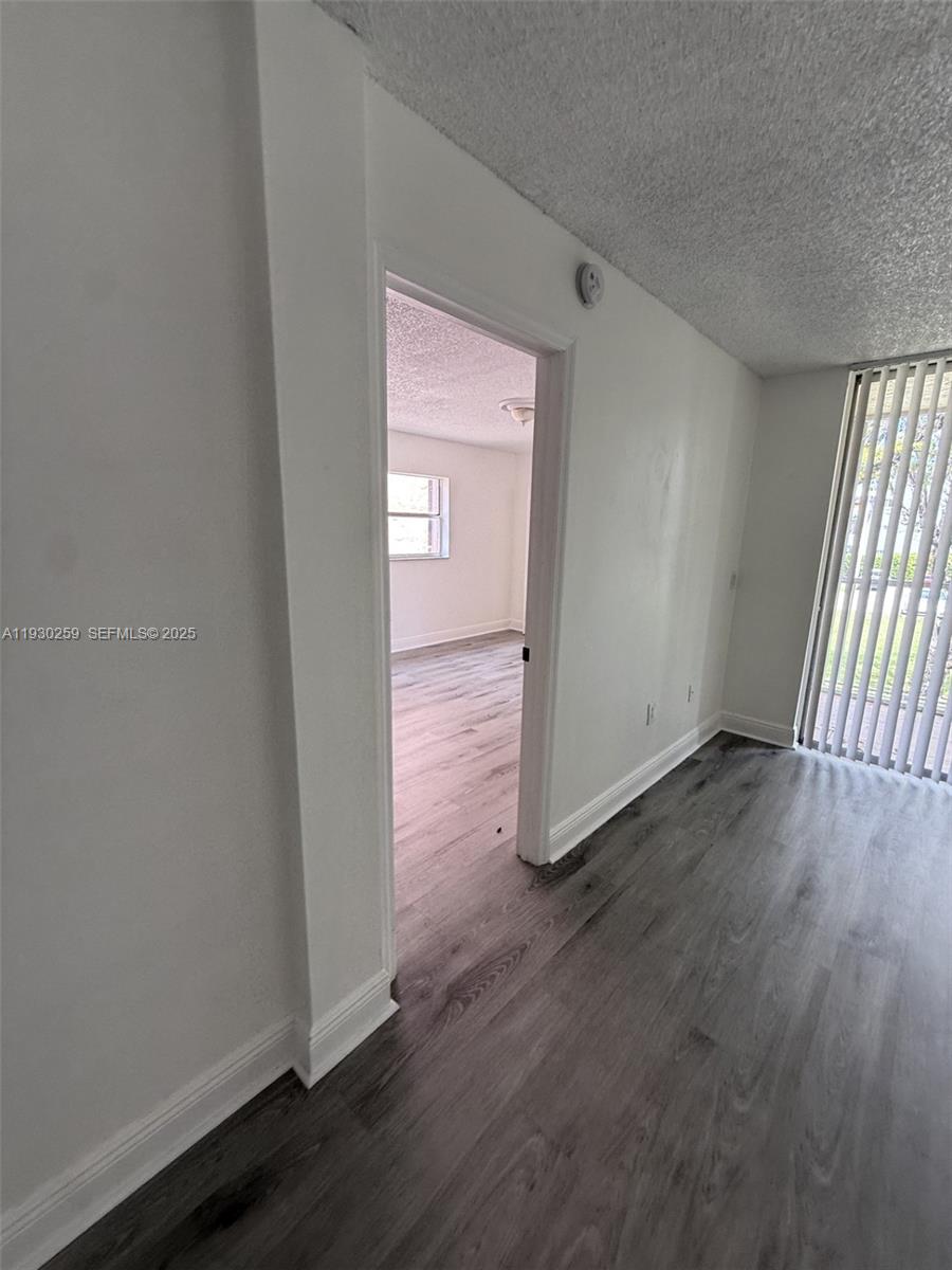 19729 Southwest 114th Avenue, Unit 251 Miami, FL 33157 - Photo 7 of 10 an empty room with wooden floor and windows