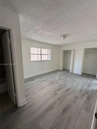 an empty room with wooden floor and window