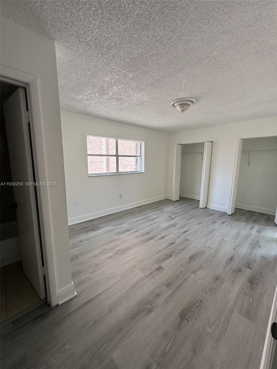 19729 Southwest 114th Avenue, Unit 251 Miami, FL 33157 - Photo 8 of 10 an empty room with wooden floor and window