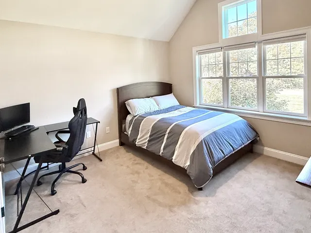 a bed sitting in a bedroom next to a window