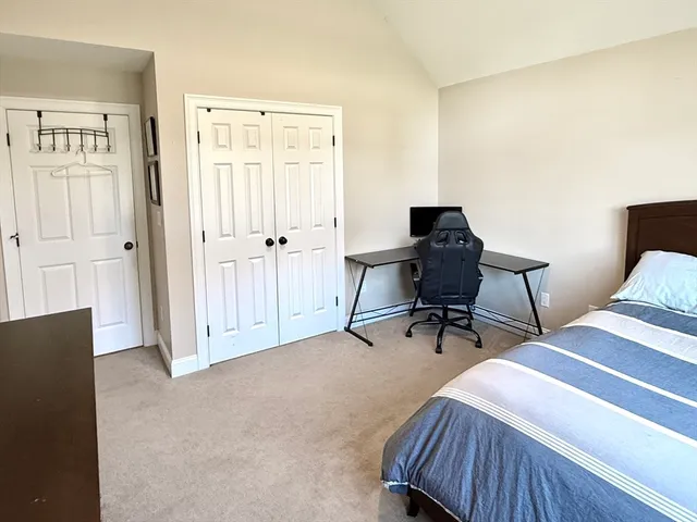 a view of a bedroom with bed and window