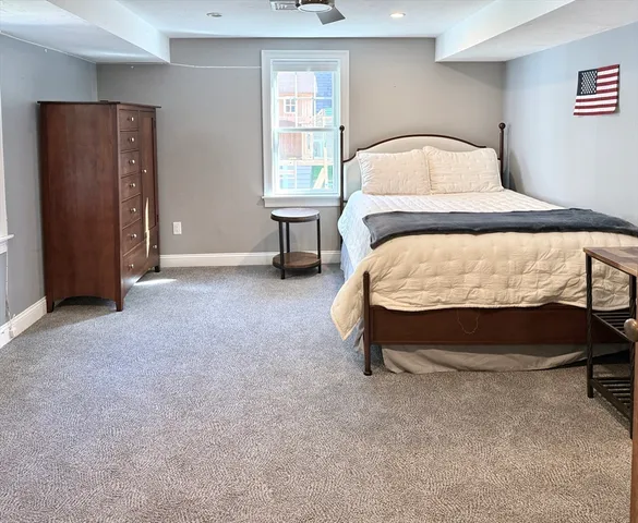 a bed sitting in a bedroom next to a window and a lamp