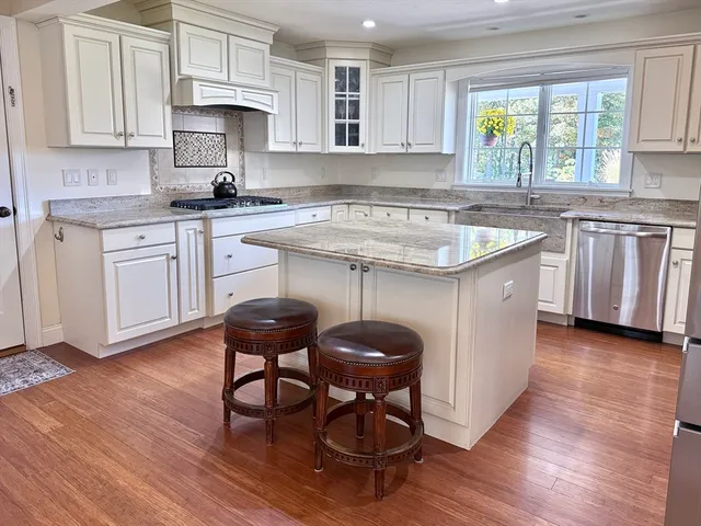 a kitchen with granite countertop a sink appliances and cabinets
